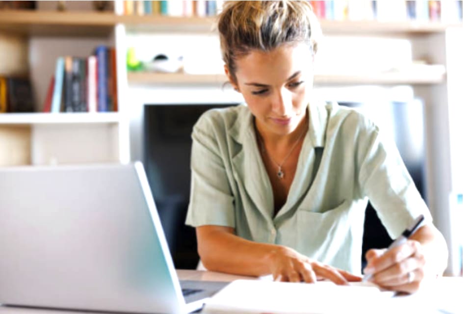 Femme étudiant et prenant des notes devant son ordinateur, représentante des élèves de la formation d’initiation à l’astrocartographie créée par Kristine Odegard.