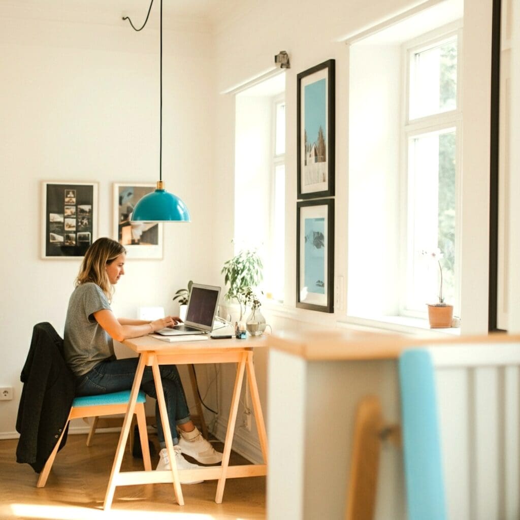 Femme travaillant à son bureau dans un espace de travail lumineux optimisé pour la concentration et la productivité grace à une consultation astrocartographique par Kristine Odegard, astrocartography certifié