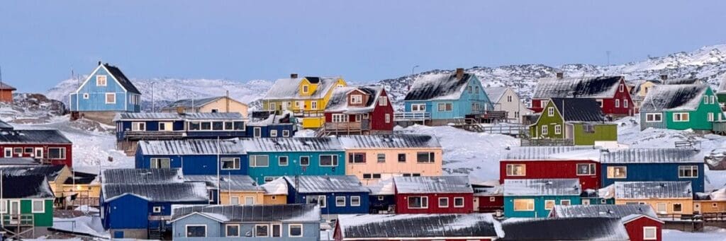 Colourful wooden houses in Nuuk, Greenland during winter, illustrating daily life in a high-latitude Arctic environment where geography, climate, and light shape lived experience and long-term human settlement.