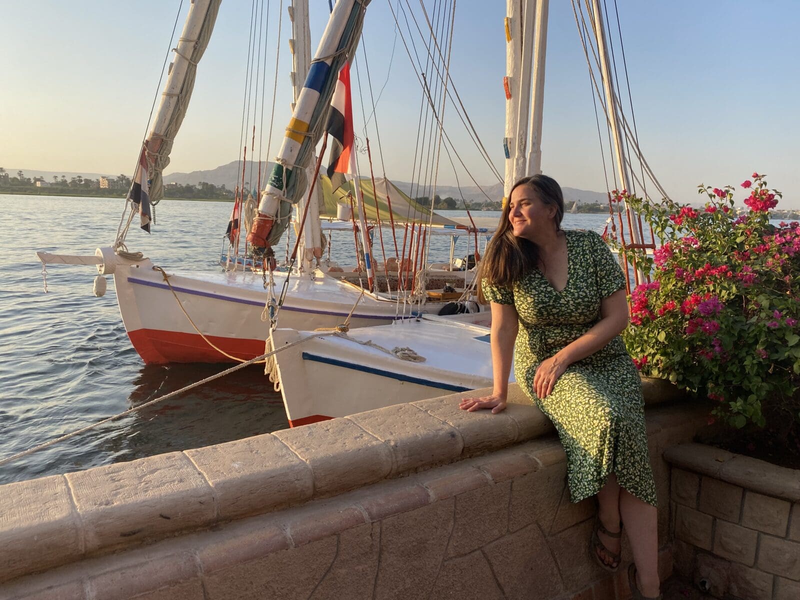 Meg Knox-Davies in Egypt by the Nile beside traditional felucca boats, photographed during international travel reflecting lived astrocartography practice within the European Astrocartography Interview Series.