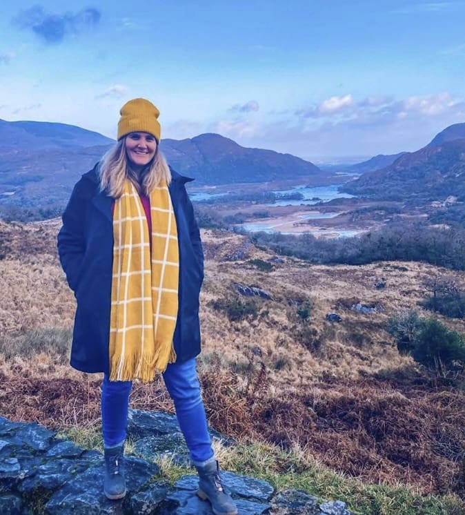 Meg Knox-Davies in Ireland overlooking a mountainous valley landscape, illustrating hemispheric relocation in astrocartography, featured in the European Astrocartography® Interview Series